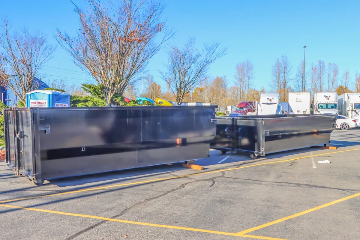 Professional dumpster rental service with roll-off container on residential driveway in West Memphis